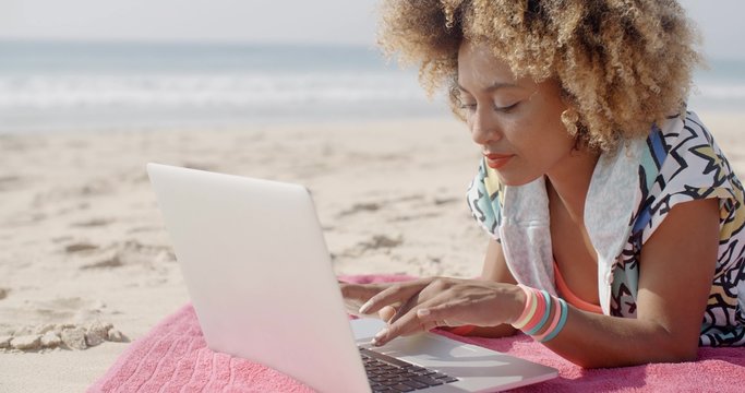 Cute woman with laptop on the summer beach