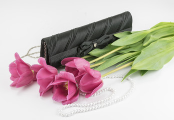 bouquet of red tulips, handbag and bead lying on a white background