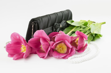 Obraz na płótnie Canvas bouquet of red tulips, handbag and bead lying on a white background