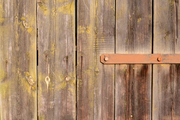 Wooden door on long iron hinge close-up