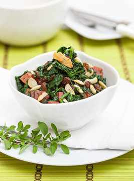 Spinach with pine seeds and ham