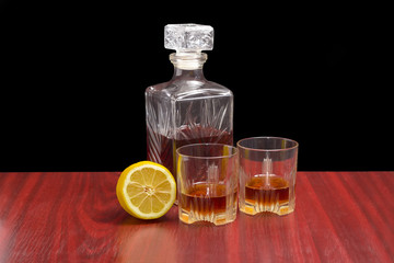 Decanter and two glasses with whiskey and lemon