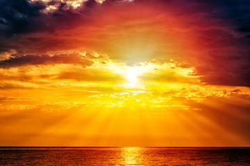 Fabulous seascape with sea and sky - yellow sun and deep red clouds above the water