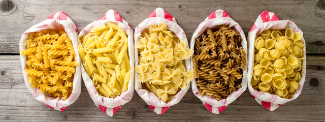 Pasta in paper bag on wooden table