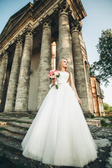 Obraz premium Gorgeous romantic gentle stylish beautiful caucasian bride on the background ancient baroque castle