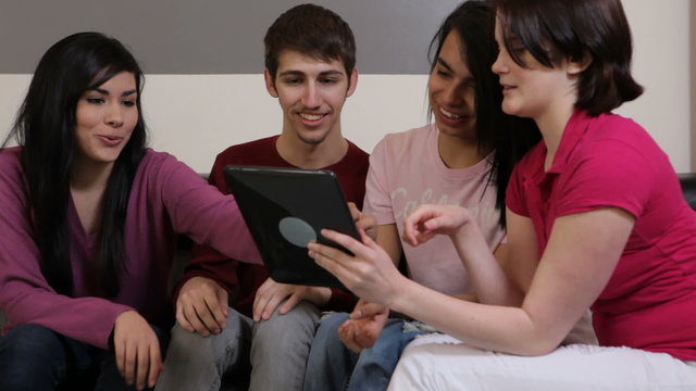 Group of young people look at digital tablet together