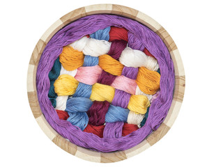 top view of the knitting in a wooden basket isolated on a white background