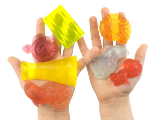 handmade color pieces of soap in kids palms isolated on a white background