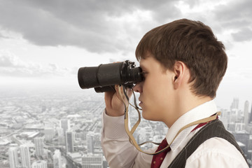 Businessman looks through a binoculars