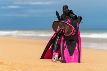Mask with tube for snorkeling and flippers on the beach