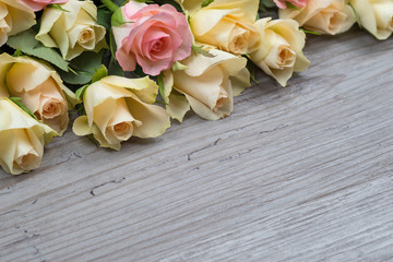 Pink and yellow roses bouquet over wooden table