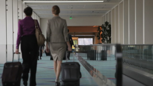 Business man runs through airport checking watch