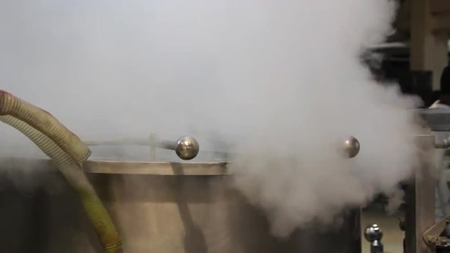 Steam escapes from the metal tank