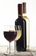 Red and white wine bottles with glasses