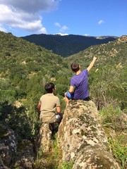 Two friends watching mountains in a sunny day.