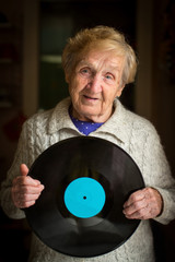 An elderly woman with the vinyl record in his hands.