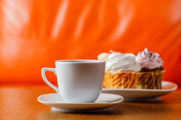 cup of tea on wood table with orange background
