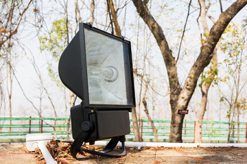 Big black spotlight or footlight set up at outdoor park with copy space