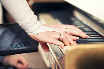 Obraz premium newlyweds play on grand piano keys