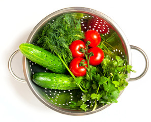 cucumbers. red tomatoes and green arugula in a metal pan