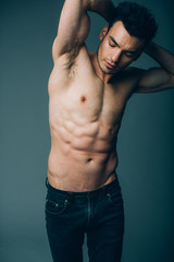 Muscular young sexy guy posing in studio in jeans and naked torso