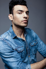 Obraz premium Portrait of handsome young man in casual denim clothes standing over white background