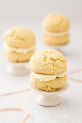 Three vanilla whoopie pies with buttercream filling on cake stand