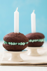 Chocolate whoopie pies with turquoise buttercream filling with candles