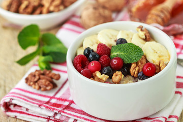 Healthy Breakfast. Oatmeal with fresh berries, bananas nuts and honey
