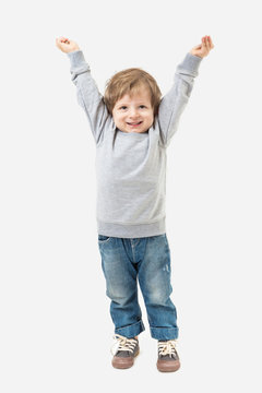 Boy playing welcomes his hands up. Grey sweater and blue jeans. Mockups template
