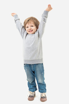Kid raised his hands to the top. Full length. Gray no image sweater and blue jeans. Mockups template