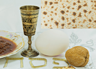 Traditional food of Jewish Passover holiday; food placed on a white festive serviette with Hebrew word -  Passover