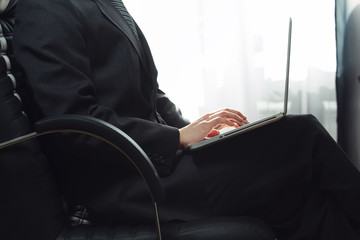 Office work. Serious business. Closeup photo of business man working on laptop no face from side. Natural colors.