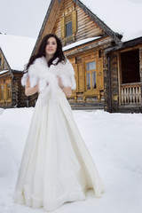 Obraz premium The bride in a fur cape in winter snowy village
