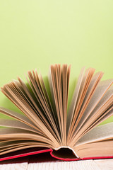 Fototapeta premium Open book on green wooden bavkground. Education background.