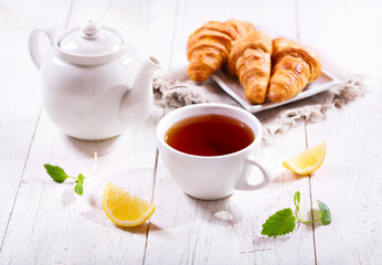 Teapot and cup of tea with mint and lemon