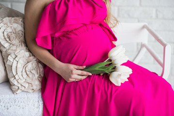 Portrait of a beautiful pregnant woman bright dress and long hair, lifestyle, waiting, belly