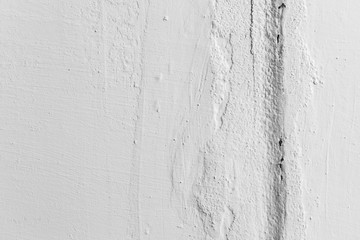 Vertical crack in white painted wall, closeup texture