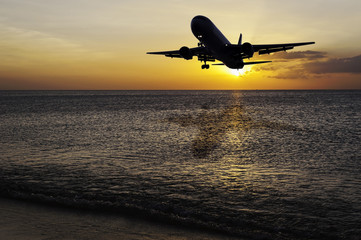 Fototapeta na wymiar Beach with plane on color of the sunset