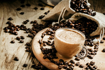 Coffee with milk, coffee maker, coffee beans, dark toned image,