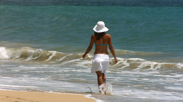 Woman walking along beach, slow motion