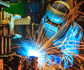 worker with protective mask welding metal