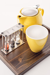 cups and teapot set with watches and loose tea in a container on white background, product for tearoom