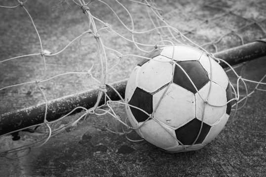 black and white old ball in the goal net 