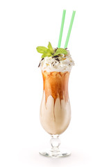 Exclusive coffe cocktail with caramel topping on glass with cream and mint leaf, isolated on white background, frappe