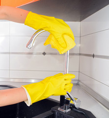 a woman doing chores in bathroom at home, cleaning sink and fauc