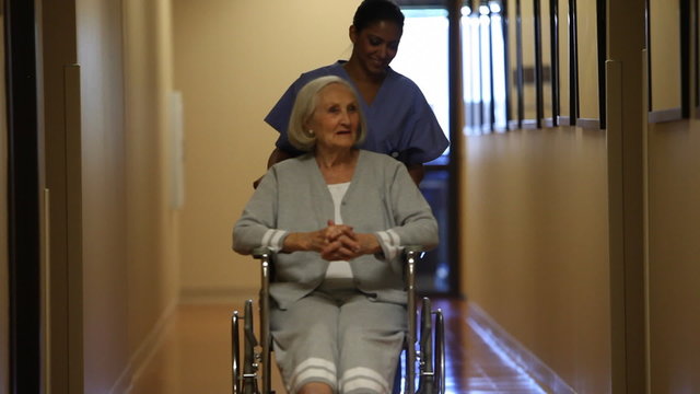 Nurse rolling patient in corridor