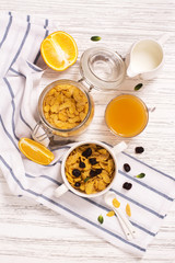 Breakfast concept with corn flakes, milk, dry cranberry and orange juice