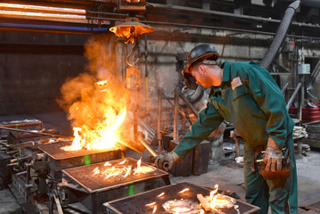 Workers in a foundry // Gruppe von Arbeitern in einer Giesserei - gießen von Gussteilen in der Fabrik