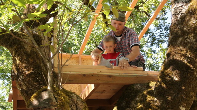 Father and son working on treehouse together